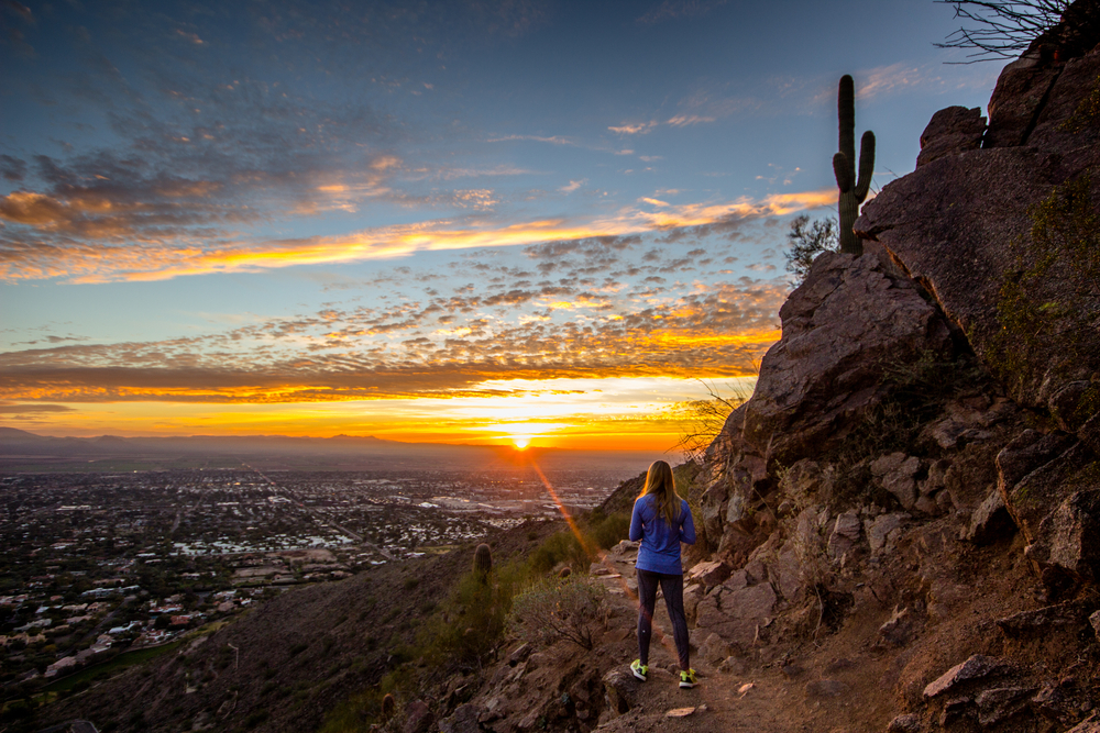 woman hiking and staring off into the sunrise