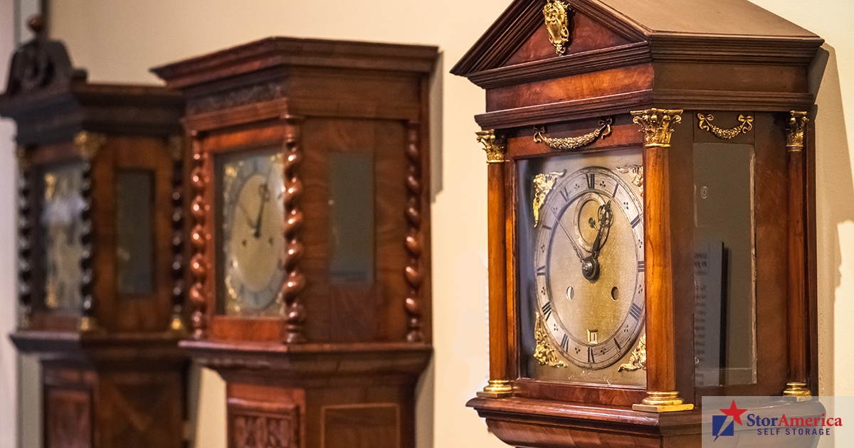 Multiple old grandfather clocks lined up next to each other